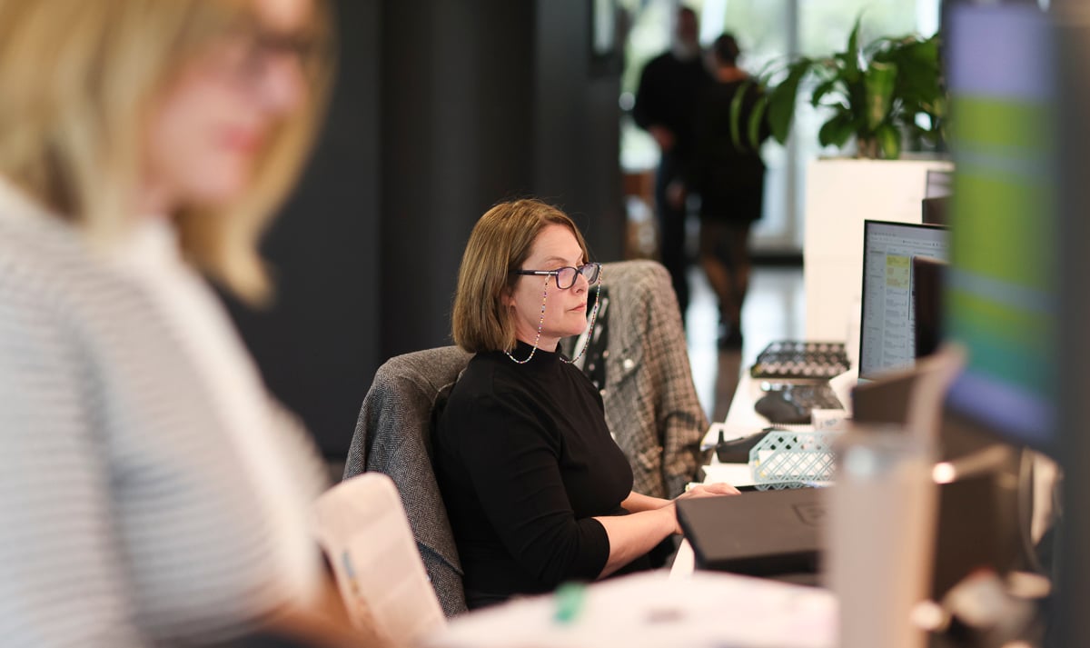 Two Prime Partners colleagues talking at a desk