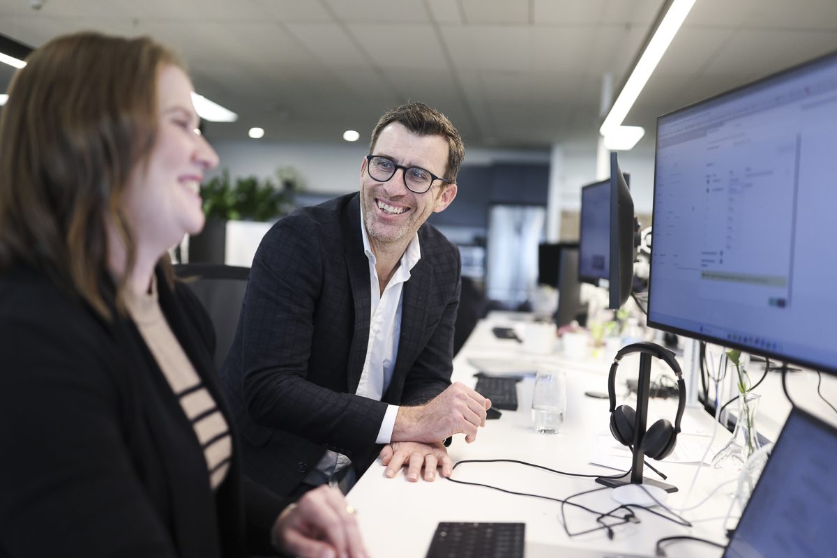 Greg Dennis and Kristina Signor talking at a desk